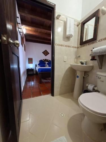 a bathroom with a toilet and a sink at Hotel Cristo Rey Campestre in Los Santos