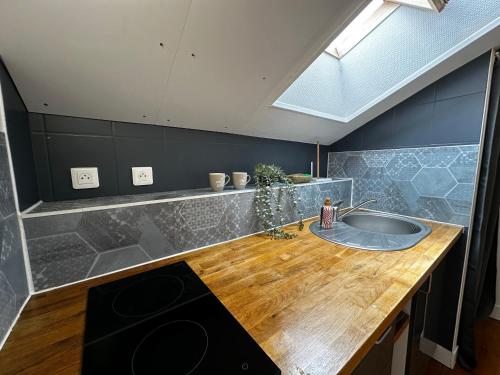 a kitchen with a sink and a wooden counter at Studio Cosy & Chic in Angoulême