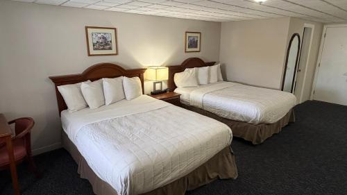 a hotel room with two beds with white sheets at Coachman Inn in Kittery