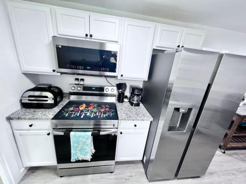 a kitchen with a stove and a refrigerator at Saint Augustine 3BR PetFriendly Fenced Backyard in St. Augustine