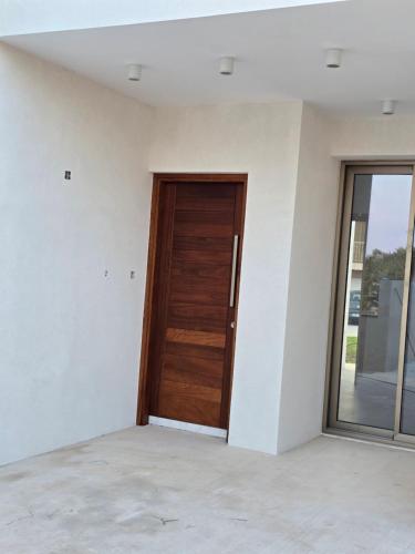 an empty room with a wooden door in it at Elia Serenity House in Anarita