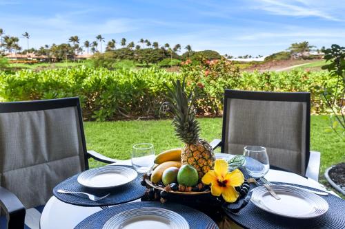 a table with a pineapple and a basket of fruit at Mauna Lani Fairways 903 in Waikoloa
