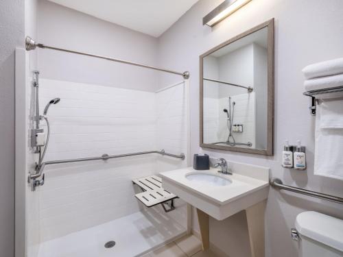 a white bathroom with a sink and a mirror at Garner Hotel Macon West by IHG in Macon