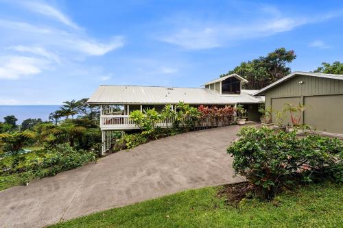 a large house with a porch and a driveway at Orchid Hale in Kailua-Kona
