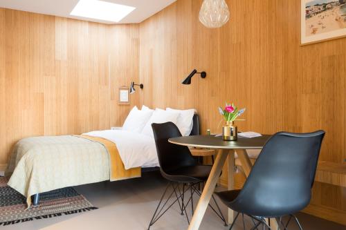 une chambre avec un lit, une table et des chaises dans l'établissement Kith & Kin Boutique Apartments, à Amsterdam