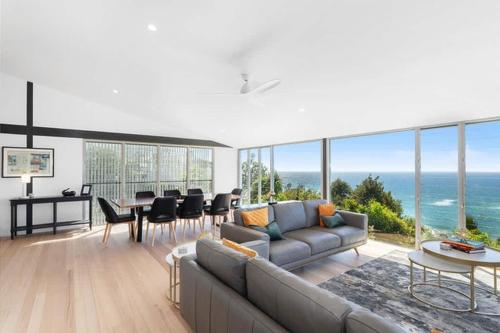 a living room with a couch and a table at Sandcastle by Coast Hosting in Wamberal