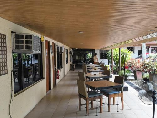 a restaurant with tables and chairs in a building at 11th Street Bed and Breakfast in Bacolod