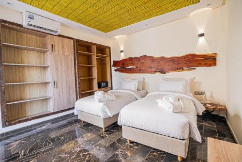 two beds in a room with white sheets at Hotel Paradise KMA in Bouznika