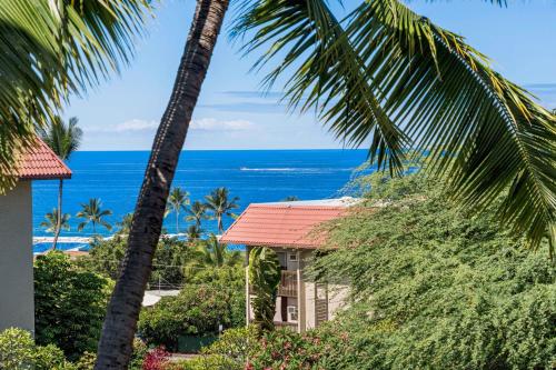 a view of the ocean from a resort with palm trees at Kona Pacific D622 in Kailua-Kona