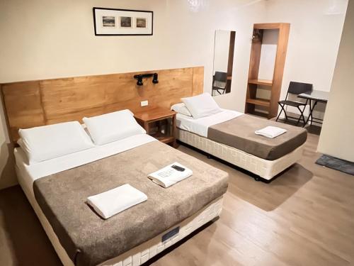 a hotel room with two beds and a table at 11th Street Bed and Breakfast in Bacolod