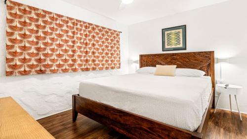 a bedroom with a bed and a wooden headboard at Casa de Emdeko 124 in Kailua-Kona