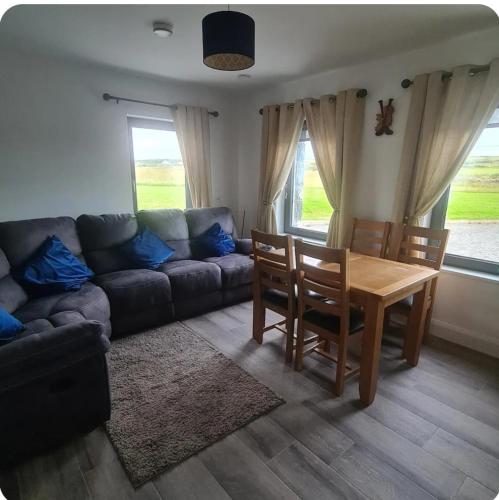 a living room with a couch and a table at Double room with ensuite in Milltown Malbay