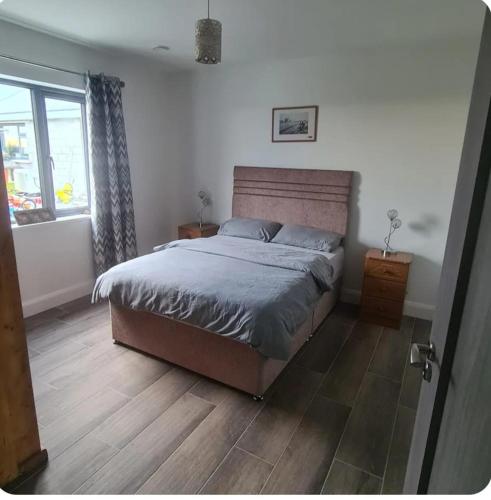 a bedroom with a bed and a window at Double room with ensuite in Milltown Malbay
