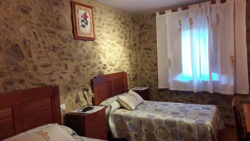 1 Schlafzimmer mit 2 Betten und einem Fenster in der Unterkunft Apartamentos Alejandra in Gargantilla