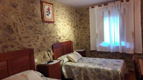 a bedroom with two beds and a window at Apartamentos Alejandra in Gargantilla