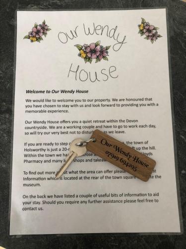 a piece of paper with a wooden spoon and flowers at Our Wendy House in Holsworthy