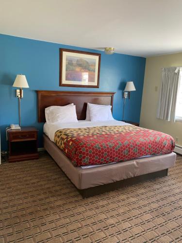 a large bed in a room with blue walls at Relax Inn in Brunswick