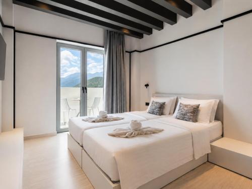 a bedroom with two beds and a large window at Veneto Sea View Apartments in Stalís
