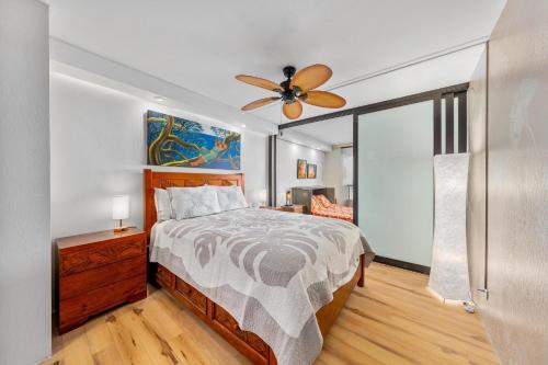a bedroom with a bed and a ceiling fan at Kona Pacific A306 in Kailua-Kona
