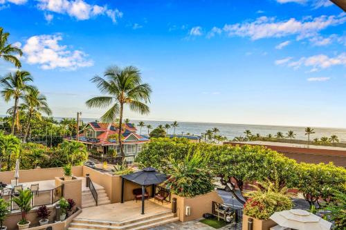 an aerial view of a resort with palm trees and the ocean at Kona Pacific A306 in Kailua-Kona