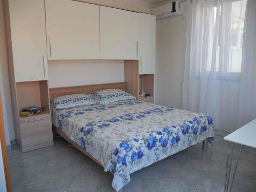 a bedroom with a bed with a blue and white comforter at Apartments JP in Jezera
