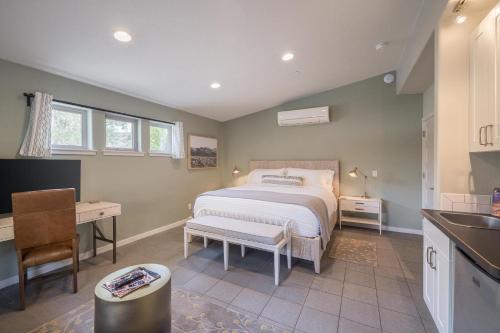 a bedroom with a bed and a desk and a kitchen at The Entrada Flat 1 in Moab UT in Moab