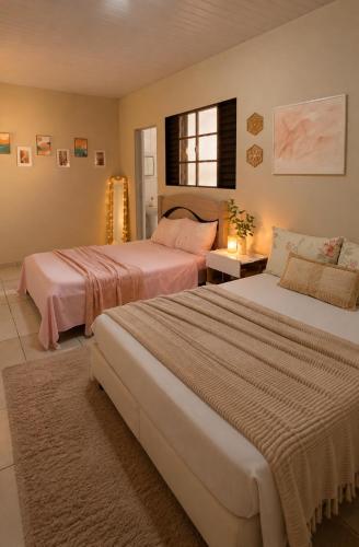two beds in a hotel room with two beds at Puxadinho do Sossego in Presidente Epitácio