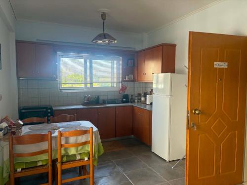a kitchen with a table and a white refrigerator at Chrisa's Apartments 1 in Missolonghi