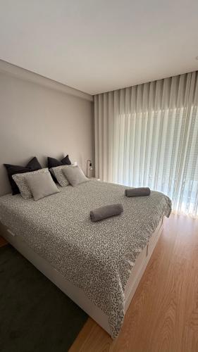 a bedroom with a large bed with two pillows on it at Apartamento de Real in Braga