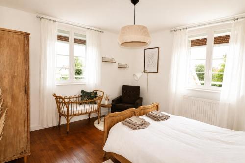 a bedroom with a bed and a chair and windows at Gite à la campagne 4 étoiles - 200m2 in Sailly
