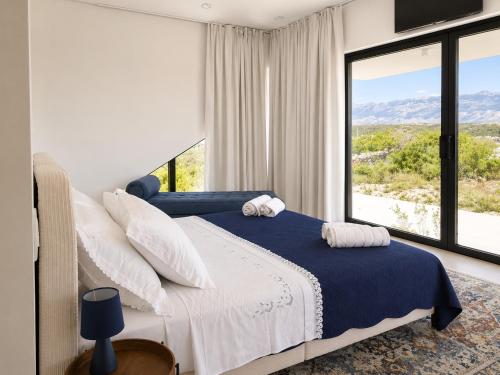 a bedroom with a bed and a large window at Villa Lunga Novalja in Novalja