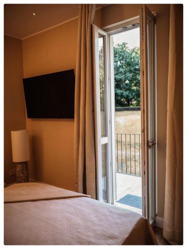 a bedroom with a bed and a sliding glass door at Adapartament in Vercelli