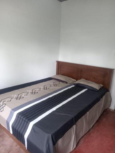 a bed with a wooden headboard in a bedroom at Down Fattna Eco Villa in Deniyaya