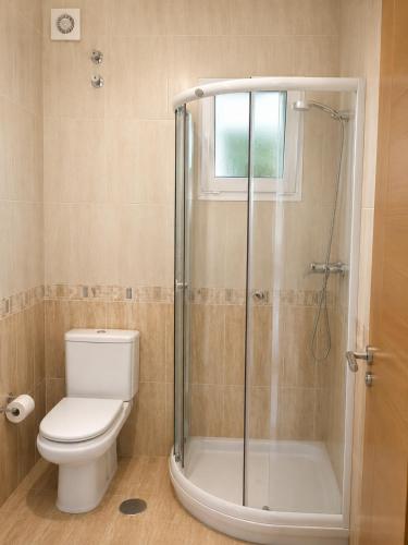 a bathroom with a toilet and a glass shower at Dunas de Corrubedo in Ribeira