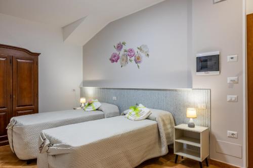 a bedroom with two beds and a clock on the wall at Villa Paradiso in Pioraco