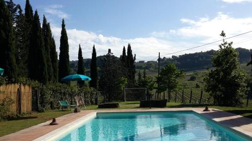 einen Pool in einem Garten mit Bäumen in der Unterkunft Agriturismo Casa Alle Vacche in San Gimignano