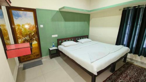 a bedroom with a bed and a window at Happy Days by 3R Munnar in Munnar