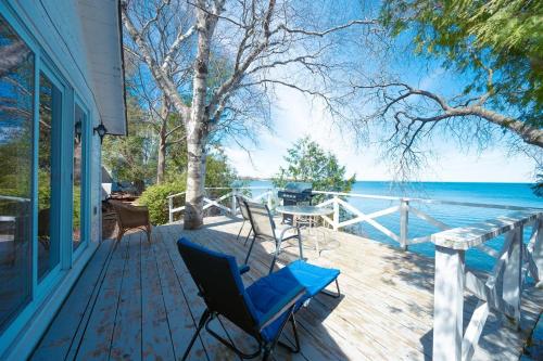 a porch with chairs and a view of the water at Lakefront Cottage Private Beach & & Kayaks in Georgina