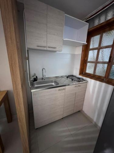 a small kitchen with a sink and a stove at ApartaHotel Los Naranjos in Apartadó