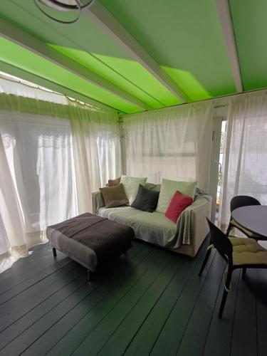 a green room with a couch and a table at L'Angolino Nascosto in Senigallia