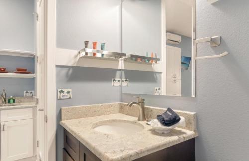 a bathroom with a sink and a mirror at Sunny Side Cottages in Dunedin