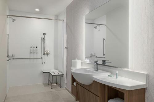 a white bathroom with a sink and a shower at SpringHill Suites by Marriott Abilene in Abilene