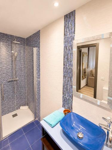 a bathroom with a blue sink and a shower at El Mirador de Alcuneza in Sigüenza