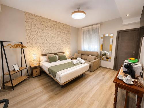 a bedroom with a large bed and a couch at El Mirador de Alcuneza in Sigüenza