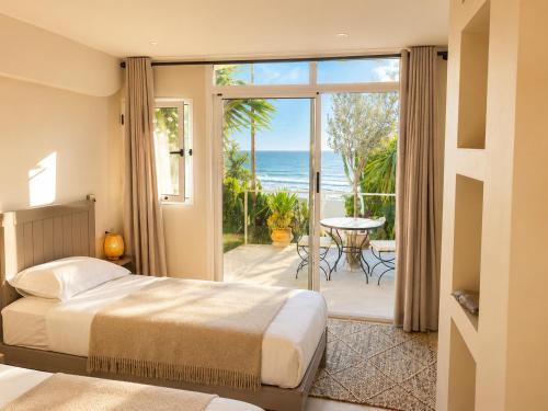 a bedroom with a bed and a view of the ocean at Villa Jardin De l'Ocean in Aourir