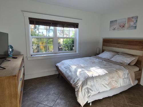 a bedroom with a bed and a window at Charming Condo - Pool, Minutes to Beach in Pompano Beach