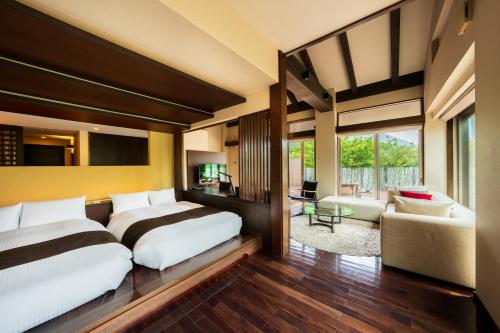 a bedroom with two beds and a living room at Okuyado Buaiso in Yufu