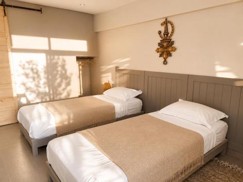 a bedroom with two beds and a chandelier at Villa Jardin De l'Ocean in Aourir