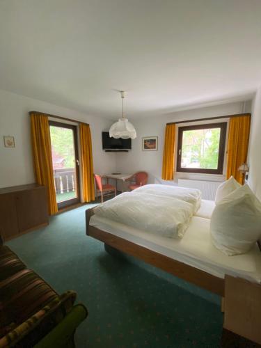 a bedroom with a large bed and two windows at Ferienwohnungen in Schönmünzach in Baiersbronn
