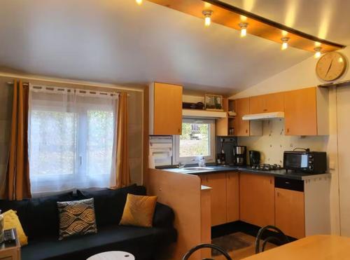 a living room with a couch and a kitchen at Mobile Home in Morbier